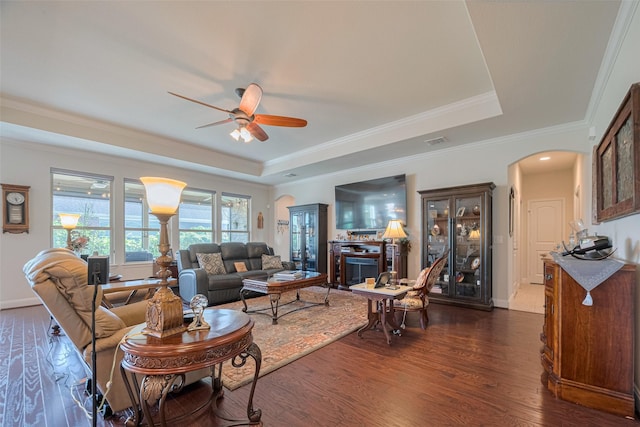 3903 Grand Fir Ct, Richmond, TX 77469 - living area with arched walkways, a raised ceiling, a ceiling fan, dark wood-type flooring, and crown molding