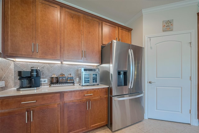 3903 Grand Fir Ct, Richmond, TX 77469 - kitchen with stainless steel fridge, ornamental molding, brown cabinets, light countertops, and tasteful backsplash