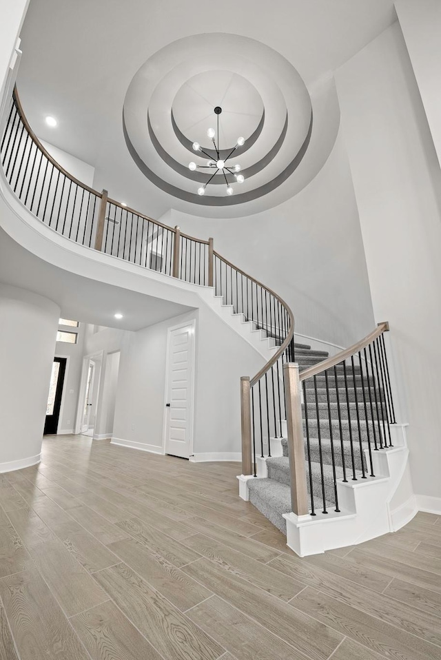 3240 Stingray Cove Dr, Katy, TX 77493 - stairway with wood finished floors, a chandelier, a high ceiling, recessed lighting, and a tray ceiling