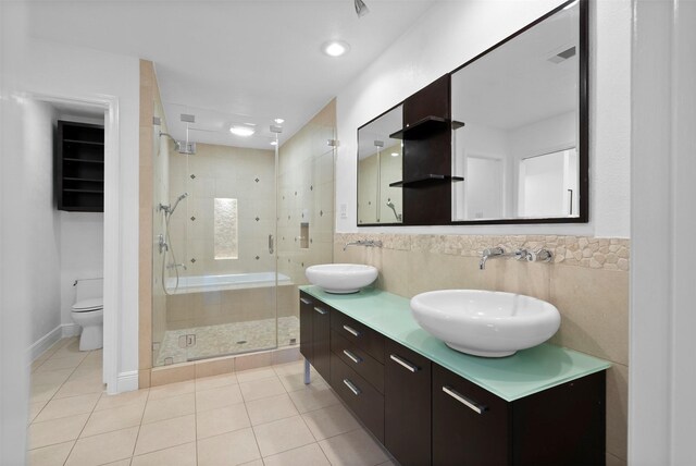 310 W Fair Harbor Ln, Houston, TX 77079 - bathroom with tile patterned floors, a shower stall, double vanity, and tile walls