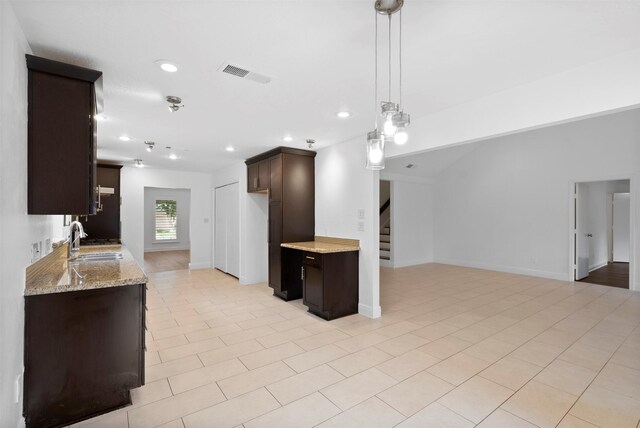 310 W Fair Harbor Ln, Houston, TX 77079 - kitchen with dark brown cabinetry, light stone counters, open floor plan, recessed lighting, and pendant lighting