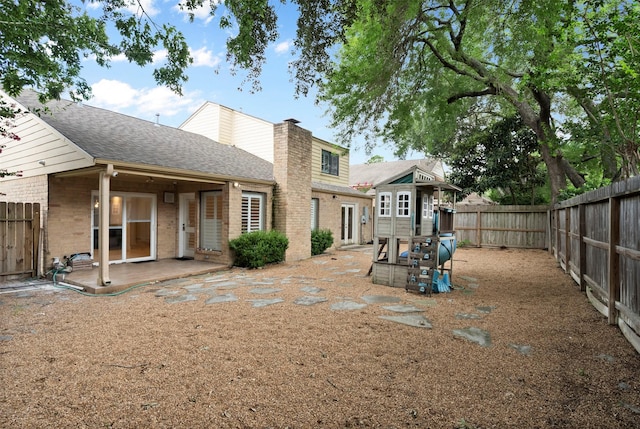 310 W Fair Harbor Ln, Houston, TX 77079 - back of property featuring a fenced backyard, brick siding, a chimney, a patio, and roof with shingles