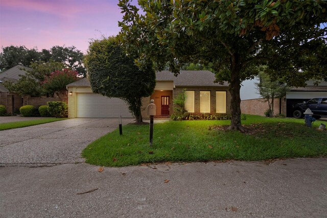 310 W Fair Harbor Ln, Houston, TX 77079 - view of front of home featuring concrete driveway, a lawn, an attached garage, and brick siding