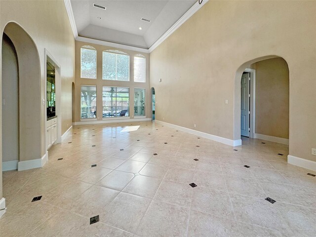 718 Marywood Chase, Houston, TX 77079 - empty room with arched walkways, a high ceiling, crown molding, light tile patterned flooring, and recessed lighting