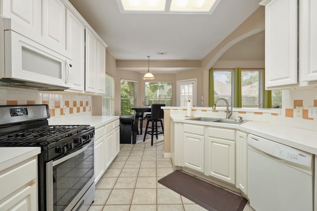 4146 S Webber Dr, Pearland, TX 77584 - kitchen featuring white appliances, decorative backsplash, white cabinets, a peninsula, and light tile patterned flooring