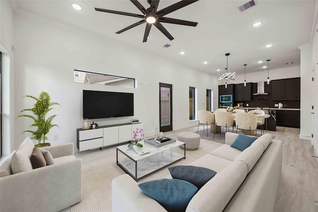 5711 Sudan St, Houston, TX 77020 - living area featuring recessed lighting, light wood-style floors, a ceiling fan, crown molding, and a chandelier