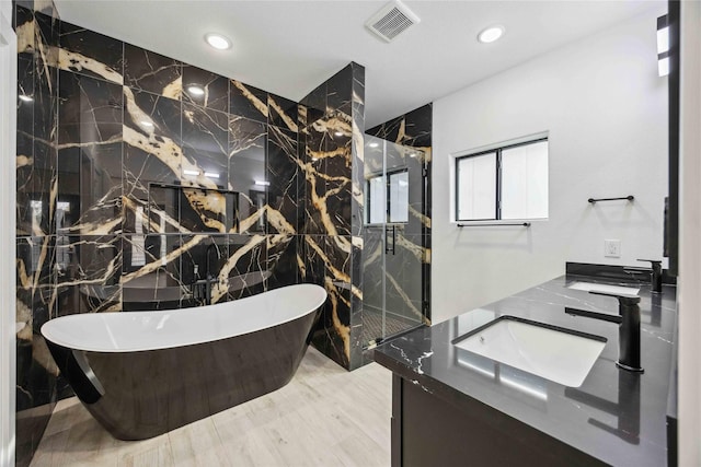5711 Sudan St, Houston, TX 77020 - full bathroom with tile walls, a freestanding bath, double vanity, a marble finish shower, and recessed lighting