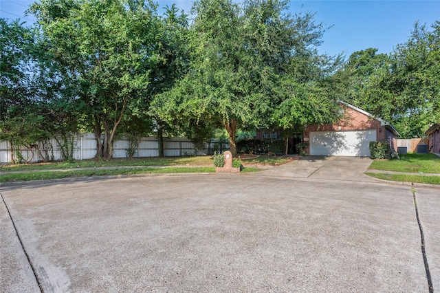 13703 Naples Park Ln, Houston, TX 77070 - view of property hidden behind natural elements featuring a garage and concrete driveway