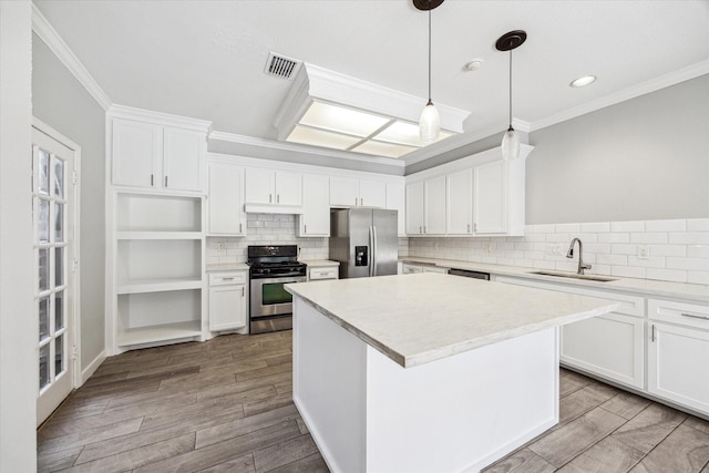 11602 Aspenway Dr, Houston, TX 77070 - kitchen featuring appliances with stainless steel finishes, a center island, backsplash, ornamental molding, and white cabinetry