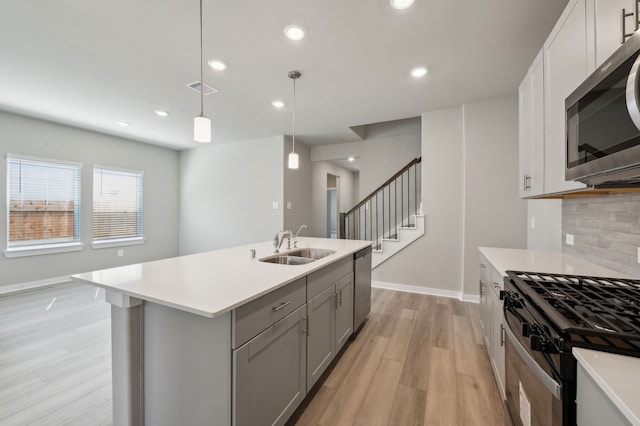 8615 Lake Groove Ln, Baytown, TX 77523 - kitchen with appliances with stainless steel finishes, gray cabinets, light wood-style floors, light countertops, and recessed lighting