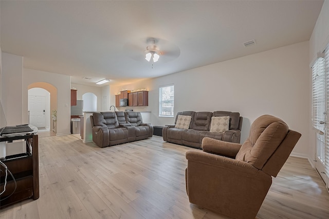 30914 Sweetwater Cir, Magnolia, TX 77355 - living room with arched walkways, a ceiling fan, and light wood-style floors