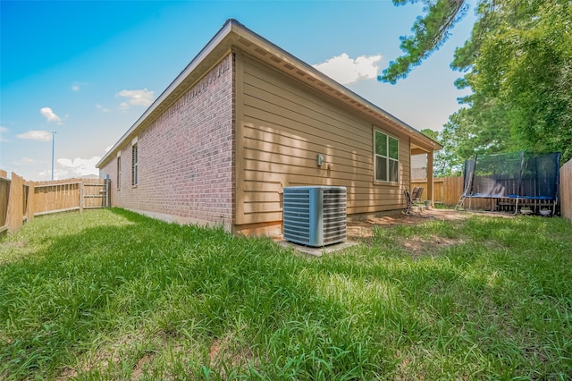 30914 Sweetwater Cir, Magnolia, TX 77355 - rear view of property featuring a trampoline, brick siding, and a fenced backyard