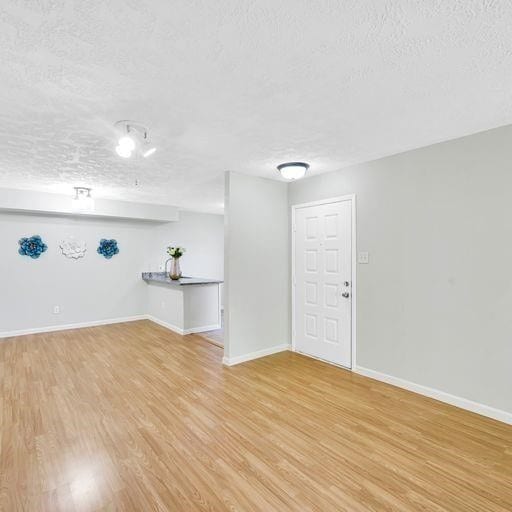 10555 Turtlewood Ct Unit 1803, Houston, TX 77072 - unfurnished room featuring a textured ceiling and light wood-style flooring