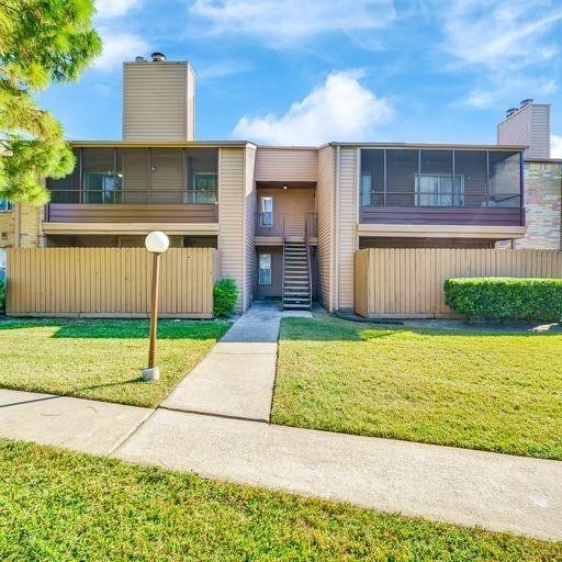 10555 Turtlewood Ct Unit 1803, Houston, TX 77072 - view of front of house featuring stairway, a chimney, and a front lawn
