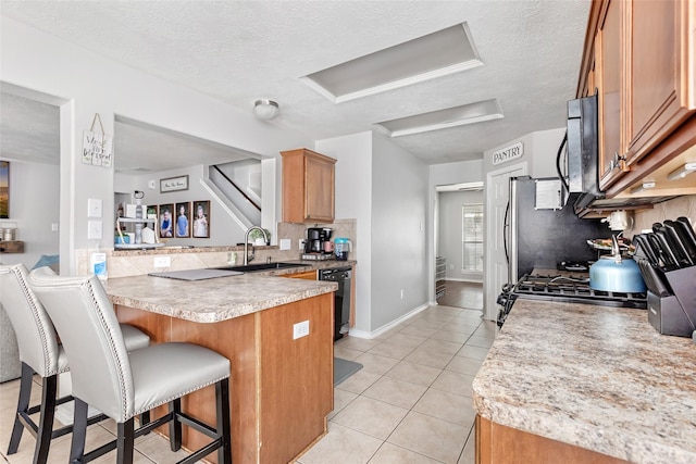 6723 Carrington Ridge Ln, Humble, TX 77346 - kitchen with a kitchen breakfast bar, dishwasher, backsplash, light tile patterned floors, and stainless steel microwave