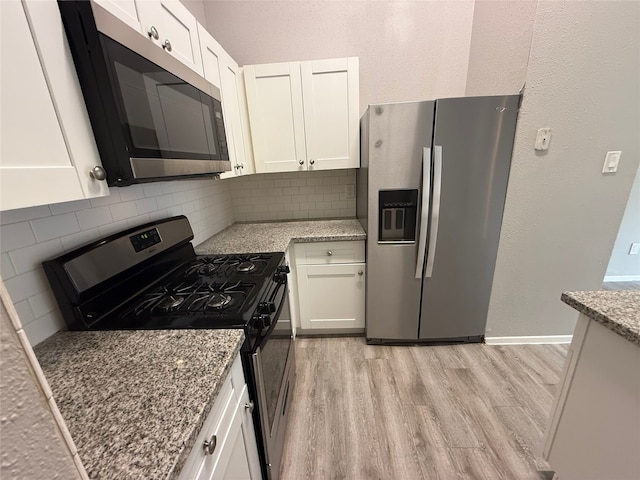 10052 Sharpton Dr, Houston, TX 77038 - kitchen with appliances with stainless steel finishes, decorative backsplash, light wood finished floors, and white cabinets
