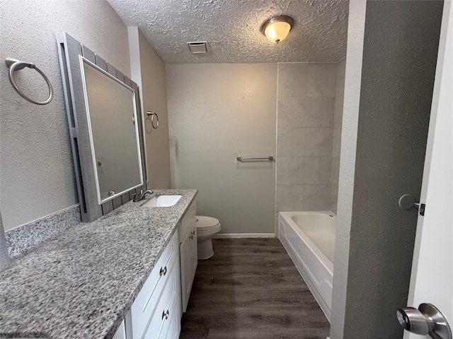 10052 Sharpton Dr, Houston, TX 77038 - bathroom featuring wood finished floors, vanity, a textured ceiling, and a textured wall