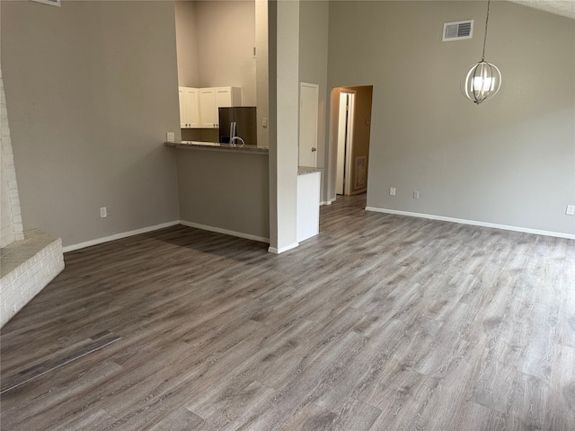 10052 Sharpton Dr, Houston, TX 77038 - unfurnished living room with high vaulted ceiling, wood finished floors, and a chandelier