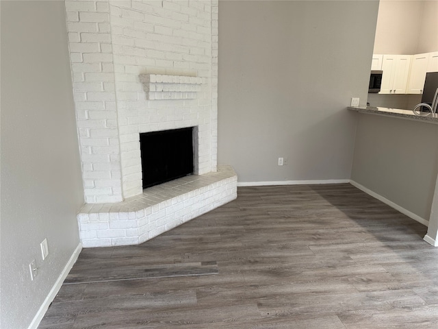 10052 Sharpton Dr, Houston, TX 77038 - unfurnished living room featuring a brick fireplace and dark wood finished floors