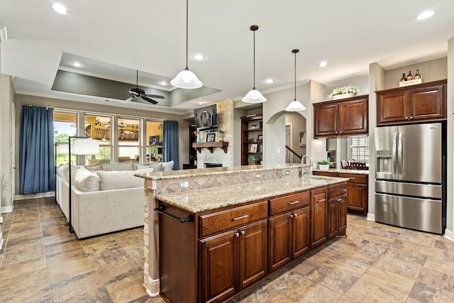 4419 Lea Ln, Fulshear, TX 77406 - kitchen with stainless steel fridge with ice dispenser, crown molding, a fireplace, ceiling fan, and open floor plan