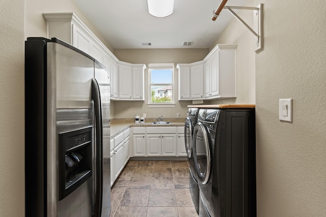 4419 Lea Ln, Fulshear, TX 77406 - laundry room with stone finish floors, washing machine and clothes dryer, and a textured wall