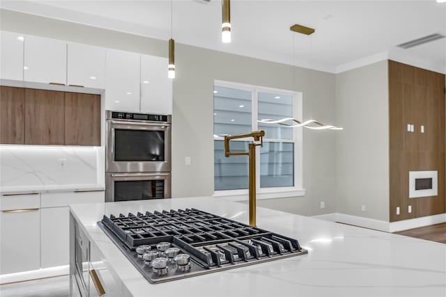 602 W 28th St Unit B, Houston, TX 77008 - kitchen with stainless steel appliances, modern cabinets, white cabinetry, and hanging light fixtures