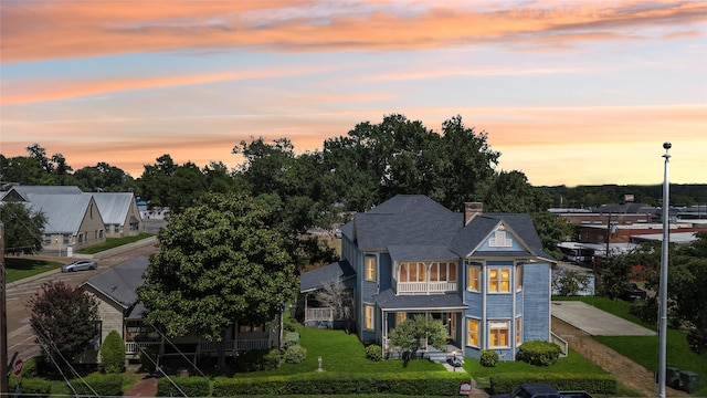 250 N Main St, Jasper, TX 75951 - back of property at dusk featuring a chimney and a yard
