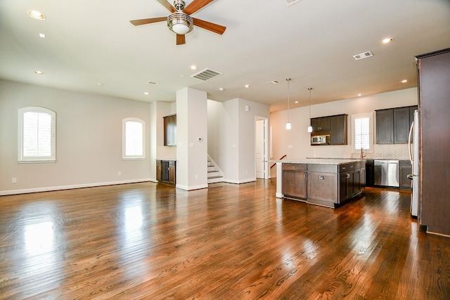 1909 Hickory St, Houston, TX 77007 - kitchen with open floor plan, stainless steel appliances, ceiling fan, dark brown cabinetry, and a kitchen island