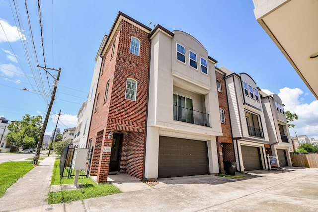 1909 Hickory St, Houston, TX 77007 - townhome / multi-family property with brick siding, a garage, stucco siding, and driveway
