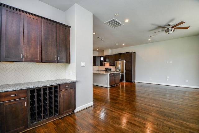 1909 Hickory St, Houston, TX 77007 - kitchen with stainless steel appliances, dark wood-style flooring, backsplash, ceiling fan, and dark brown cabinets