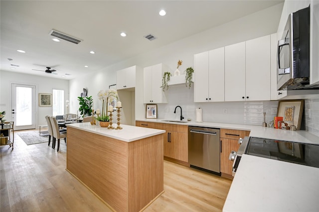 4009 New Orleans St A/B, Unit A/B Houston, TX 77020 - kitchen with appliances with stainless steel finishes, light countertops, light wood-style floors, decorative backsplash, and a kitchen island