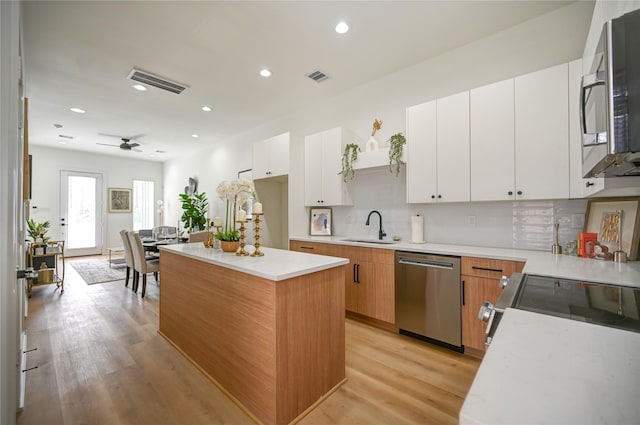 4009 New Orleans St A/B, Unit A/B Houston, TX 77020 - kitchen featuring stainless steel appliances, light countertops, a center island, light wood finished floors, and backsplash