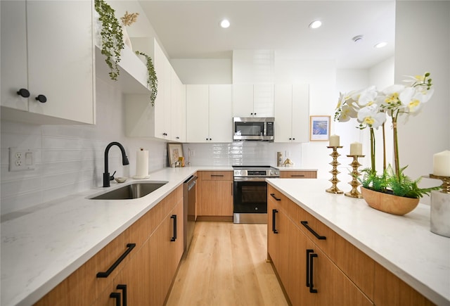 4009 New Orleans St A/B, Unit A/B Houston, TX 77020 - kitchen featuring stainless steel appliances, decorative backsplash, light wood finished floors, recessed lighting, and white cabinets
