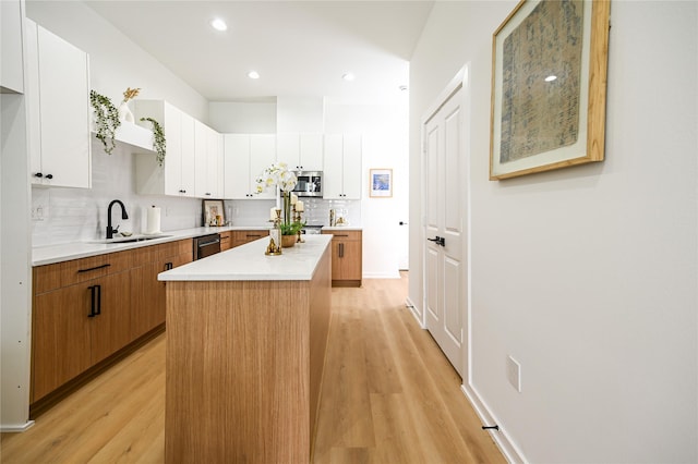 4009 New Orleans St A/B, Unit A/B Houston, TX 77020 - kitchen with appliances with stainless steel finishes, light wood-style flooring, tasteful backsplash, light countertops, and a center island