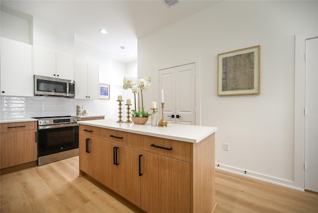 4009 New Orleans St A/B, Unit A/B Houston, TX 77020 - kitchen featuring stainless steel appliances, light wood finished floors, light countertops, a center island, and tasteful backsplash