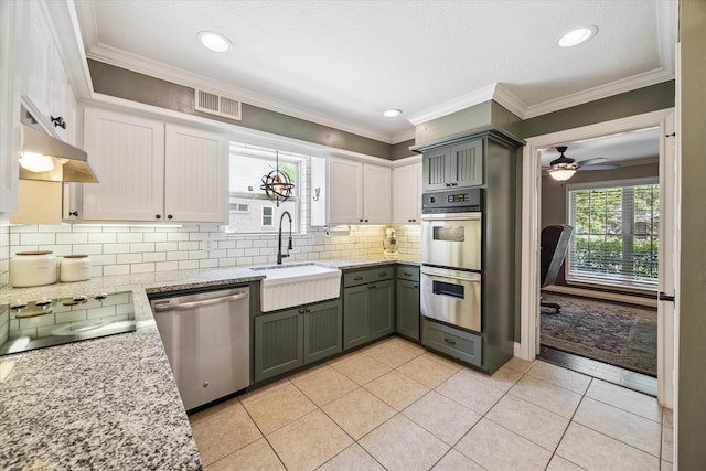 607 Ellingham Dr, Katy, TX 77450 - kitchen with stainless steel appliances, light stone countertops, ceiling fan, decorative backsplash, and under cabinet range hood