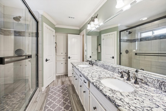607 Ellingham Dr, Katy, TX 77450 - bathroom featuring double vanity, a stall shower, wood finished floors, and ornamental molding