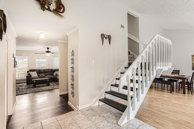 1902 Pepperrell Place Ct, Katy, TX 77493 - stairway featuring a textured ceiling, ceiling fan, wood finished floors, and ornamental molding