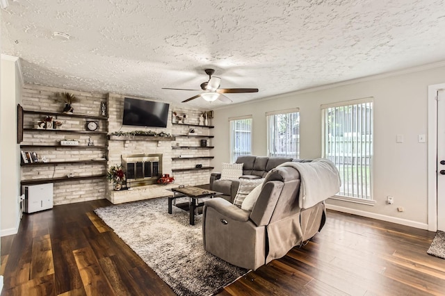 1902 Pepperrell Place Ct, Katy, TX 77493 - living room featuring a textured ceiling, dark wood finished floors, ceiling fan, a brick fireplace, and ornamental molding