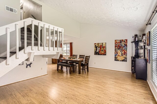 1902 Pepperrell Place Ct, Katy, TX 77493 - dining room with a textured ceiling, lofted ceiling, wood finished floors, and stairway