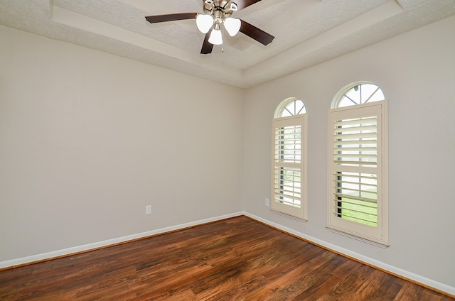 22127 Kerryblue Dr, Katy, TX 77450 - empty room with a raised ceiling, dark wood-style flooring, ceiling fan, and a textured ceiling
