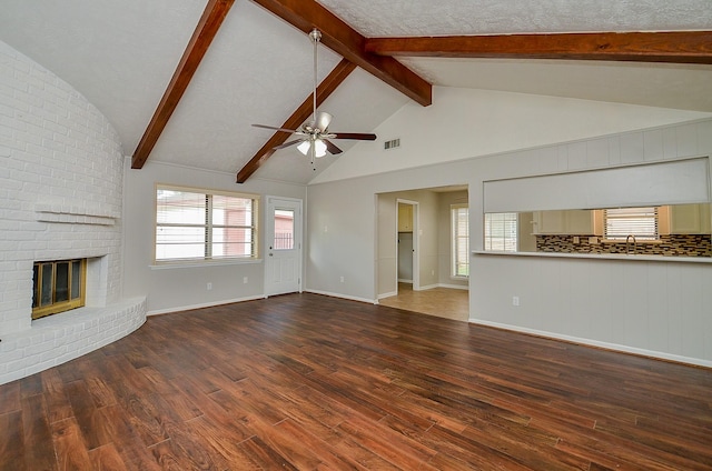 22127 Kerryblue Dr, Katy, TX 77450 - unfurnished living room featuring a brick fireplace, ceiling fan, wood finished floors, beam ceiling, and high vaulted ceiling
