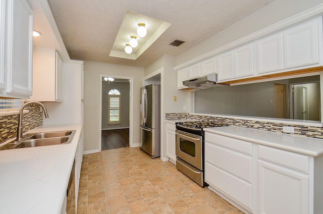22127 Kerryblue Dr, Katy, TX 77450 - kitchen featuring stainless steel appliances, under cabinet range hood, decorative backsplash, white cabinetry, and light countertops