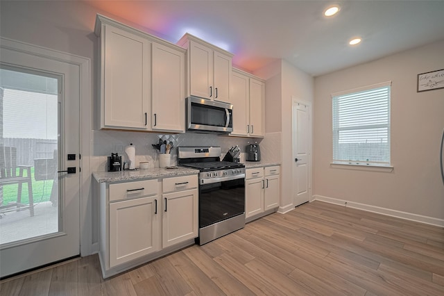 3213 Overfalls Dr, Santa Fe, TX 77510 - kitchen with stainless steel appliances, tasteful backsplash, recessed lighting, light wood-style floors, and white cabinets