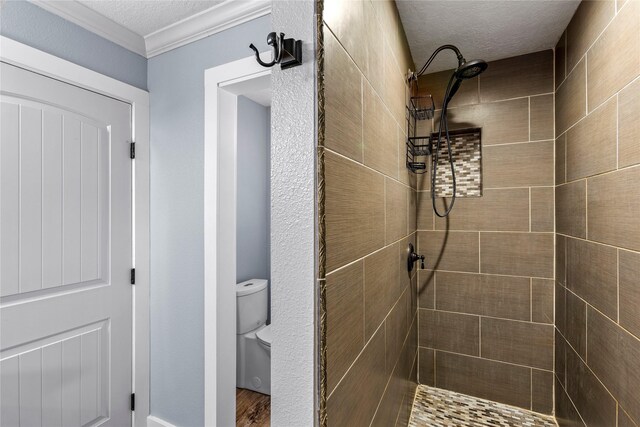 112 April Wind Dr E, Montgomery, TX 77356 - full bathroom with tiled shower, a textured ceiling, wood finished floors, and ornamental molding