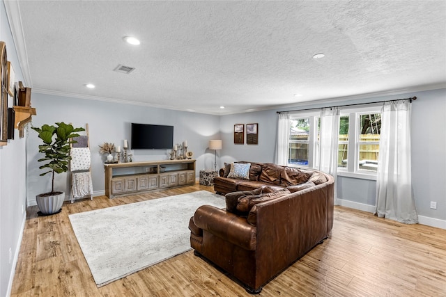112 April Wind Dr E, Montgomery, TX 77356 - living area featuring ornamental molding, light wood-style flooring, a textured ceiling, and recessed lighting