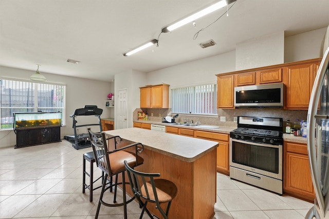 1327 Bartlett Cove Dr, Houston, TX 77067 - kitchen featuring stainless steel appliances, light countertops, backsplash, a center island, and a breakfast bar