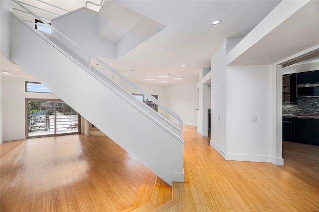 18405 Sandy Cv, Houston, TX 77058 - staircase featuring wood finished floors and recessed lighting
