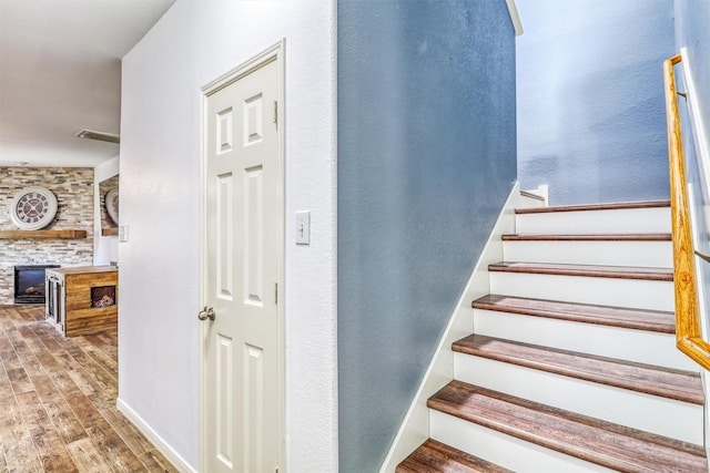 2726 Indigo Stone Ln, Katy, TX 77449 - staircase with wood finished floors and a stone fireplace