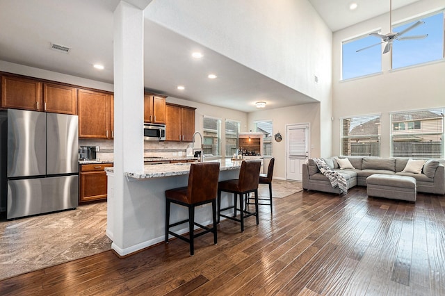 9215 Union Meadow Ln, Cypress, TX 77433 - kitchen with appliances with stainless steel finishes, dark wood finished floors, open floor plan, light stone countertops, and a high ceiling